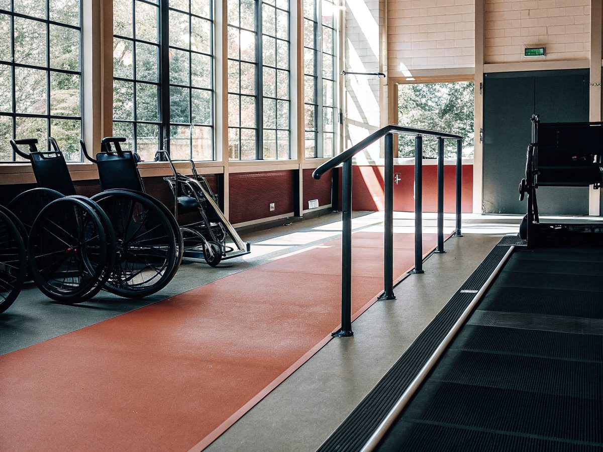 A wheelchair-accessible gym with adaptive equipment and racing wheelchairs