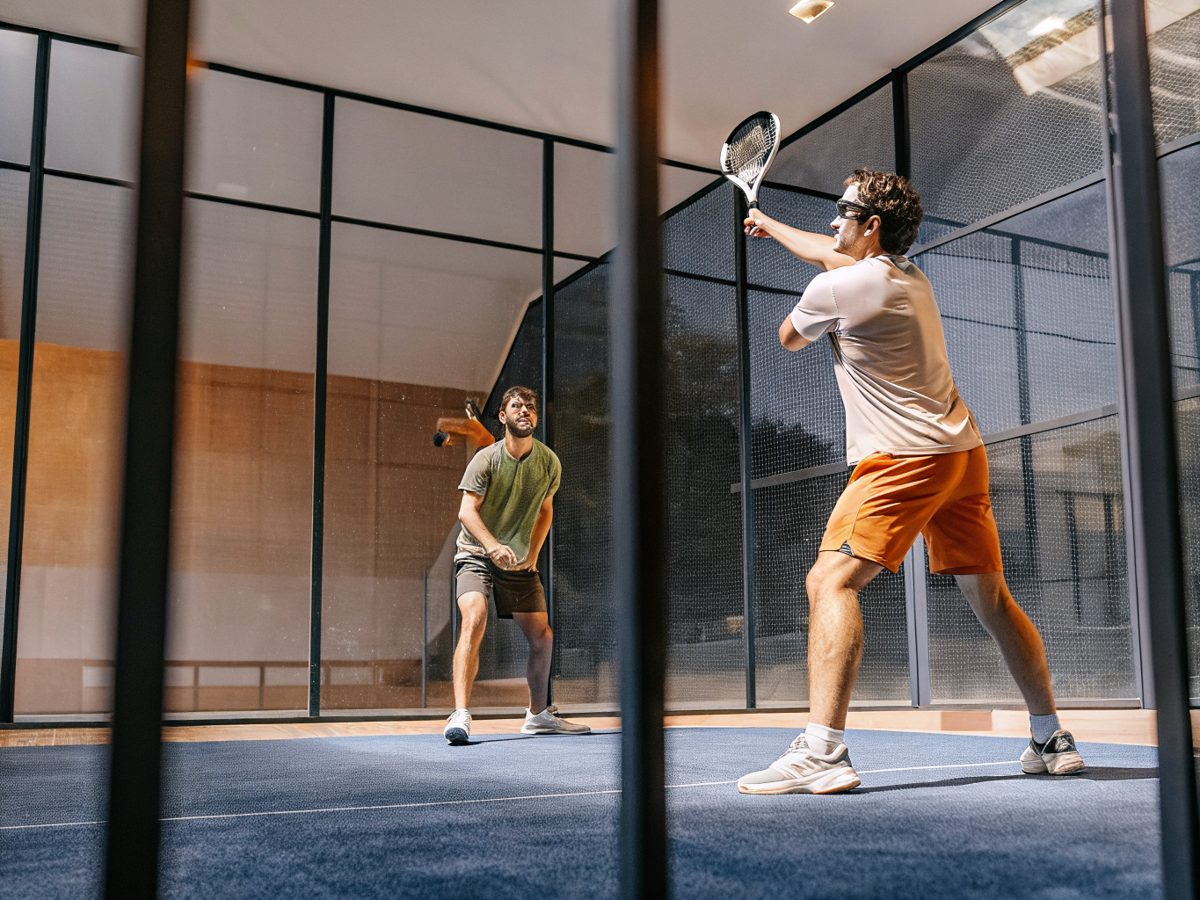 Two players in action on an indoor padel court