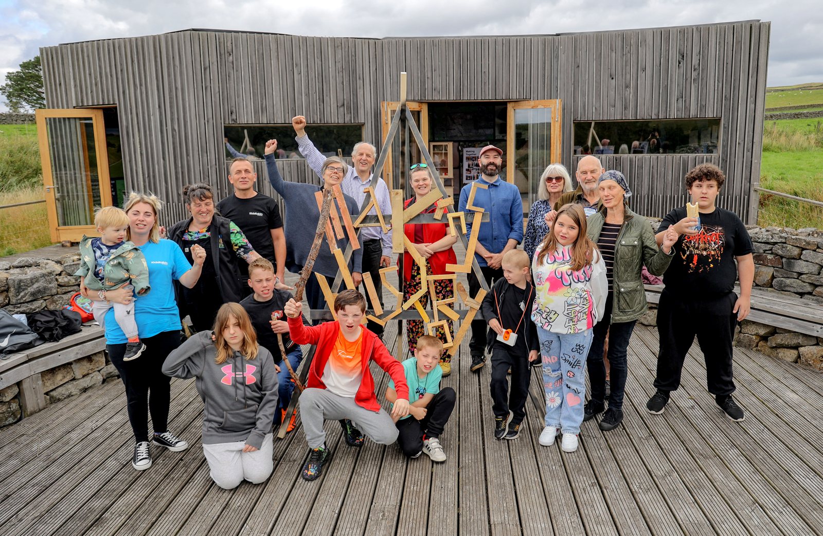 Kids Kabin children and staff outside their workshop with a handmade "Makers History" sculpture