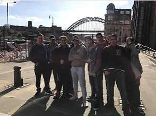 A group of young people on an outing with the Tyne Bridge behind them