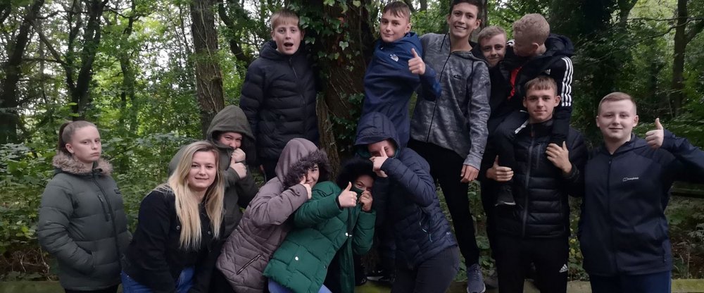 A group of young people together in woodland